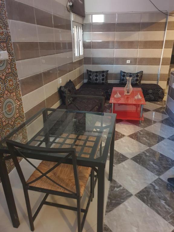 - un salon avec une table en verre et un canapé dans l'établissement Maison de ville, à Oulad Hamdane