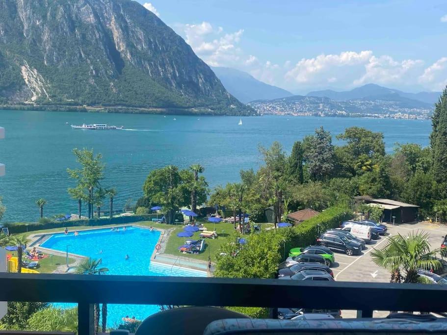 vistas a una piscina junto a un lago en Apartment Bella Vista Lugano, en Bissone