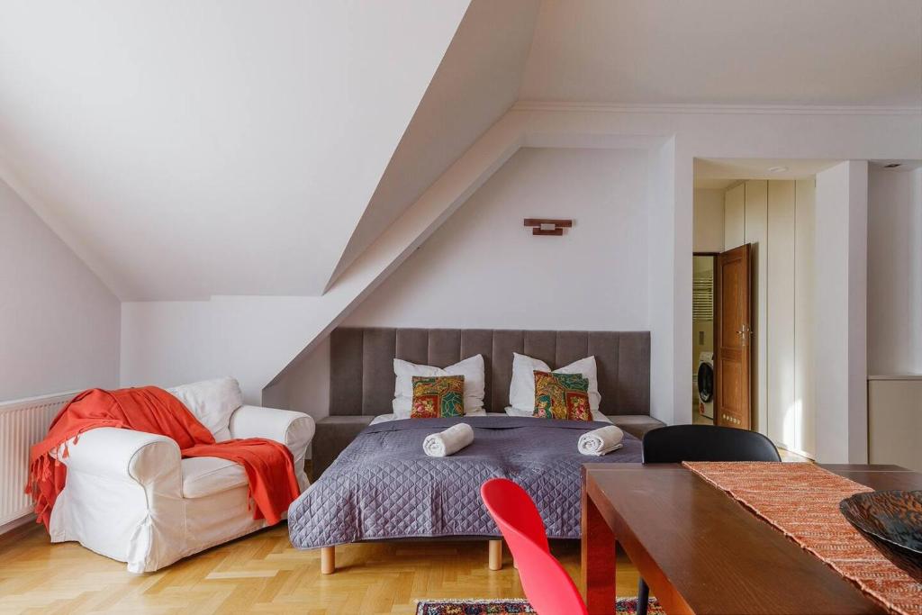 a bedroom with a bed and a chair and a table at Golden Apartments Zakopane&S3 in Zakopane