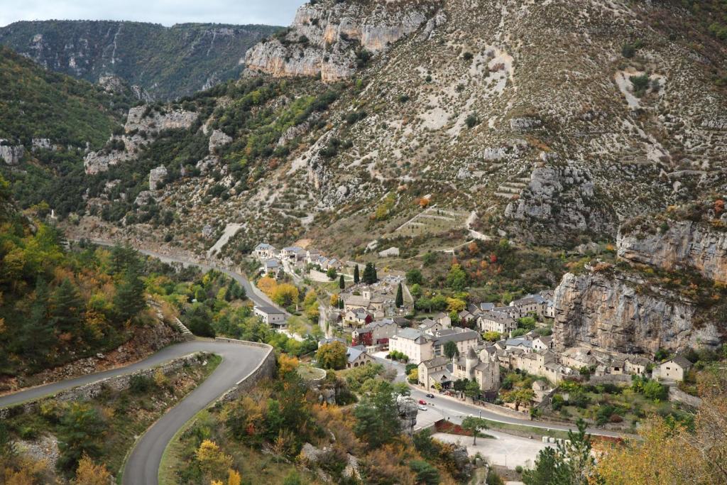 un camino sinuoso en las montañas con un pueblo en Gîte de la Batelière, en La Malène