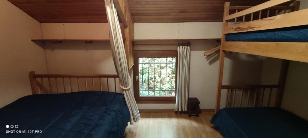a bedroom with two bunk beds and a window at Gîte de la Batelière in La Malène