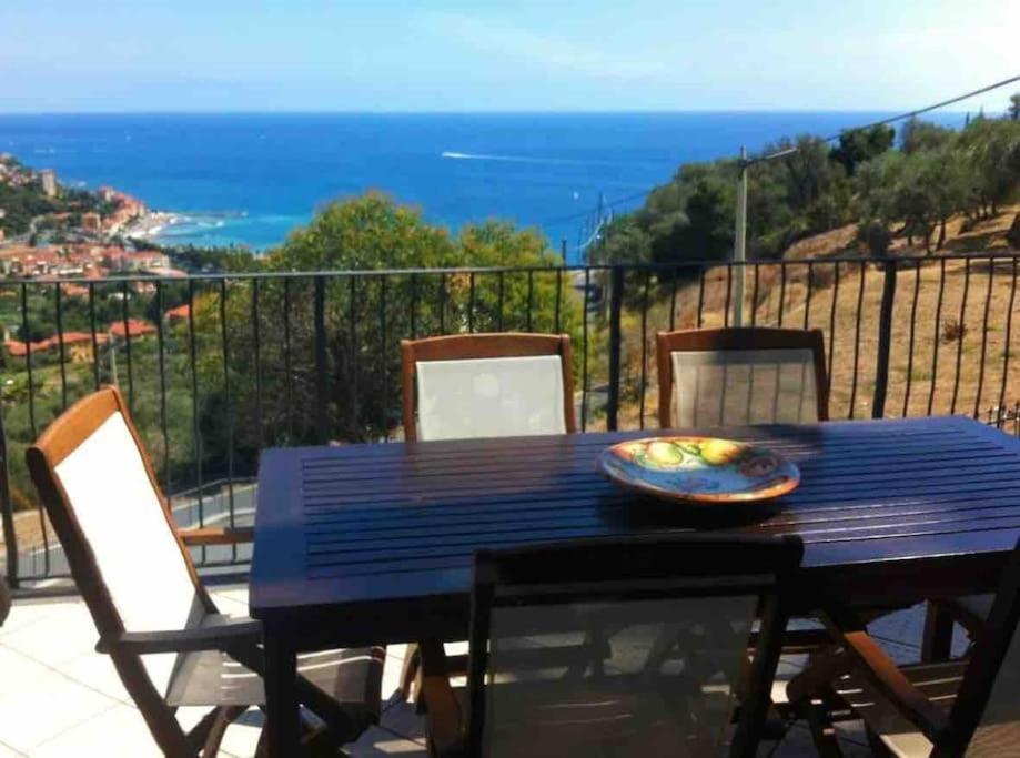 d'une table bleue et de chaises sur un balcon donnant sur l'océan. dans l'établissement Terrazza Bay View, à Imperia