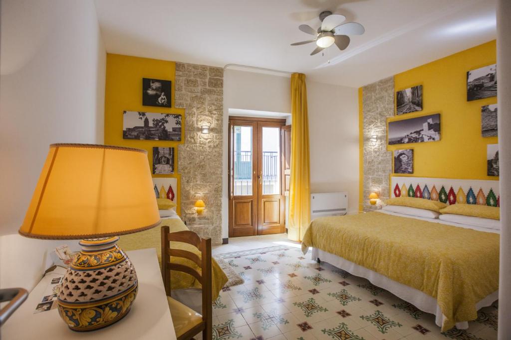 una camera con letto e tavolo con lampada di Antico Borgo a Erice