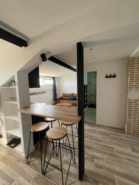 a kitchen with a table and stools in a room at Villa Corbelle - Grand Studio in Cannes