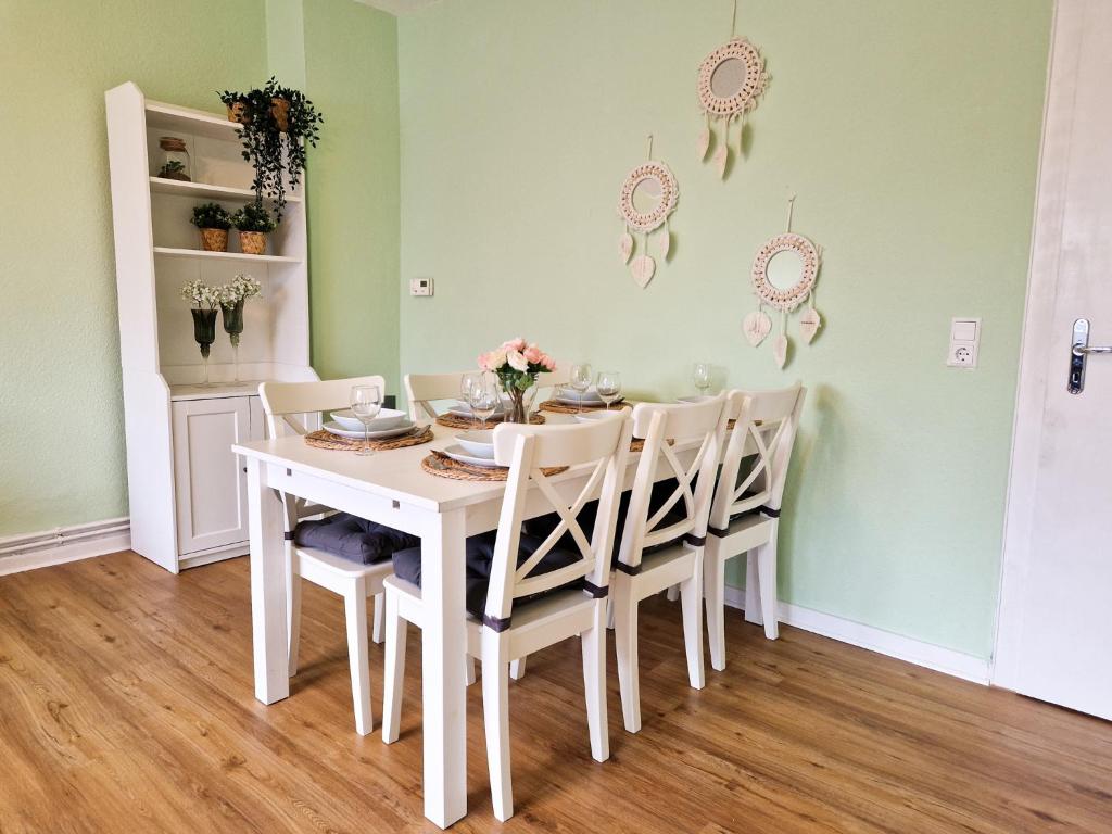a dining room with a white table and chairs at Apartment beim Theater in Hildesheim