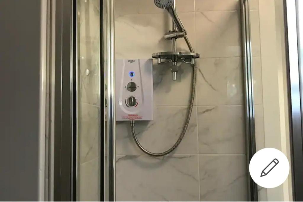 a shower with a shower head in a bathroom at 1 bed apartment in West London in Heston