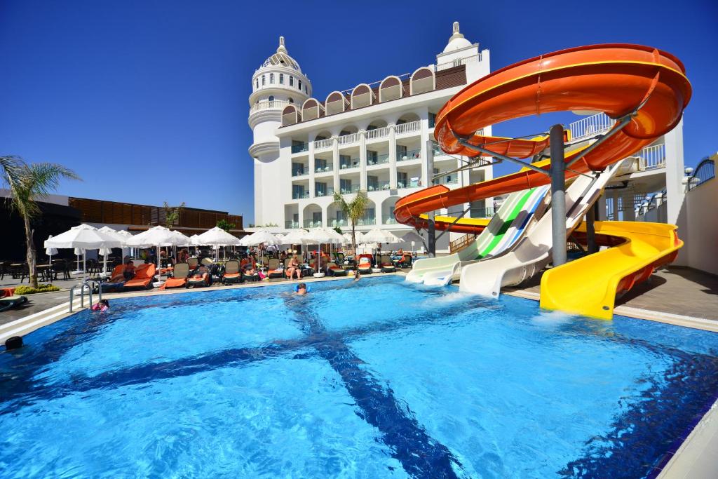 a pool with a slide in front of a hotel at Side Crown Serenity All Inclusive in Side