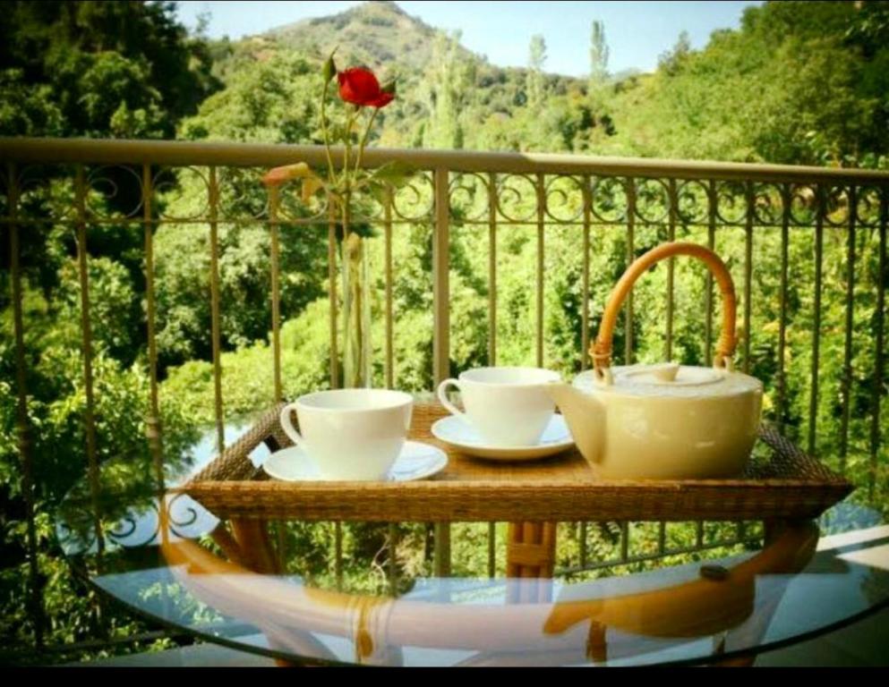 a table with two cups and a sink on a balcony at Riverside Suite in Kalopanayiotis