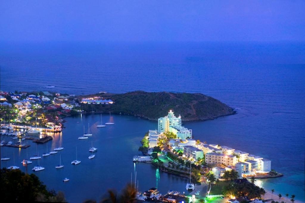 an island with boats in a harbor at night at Oyster Bay Beach Resort in Dawn Beach