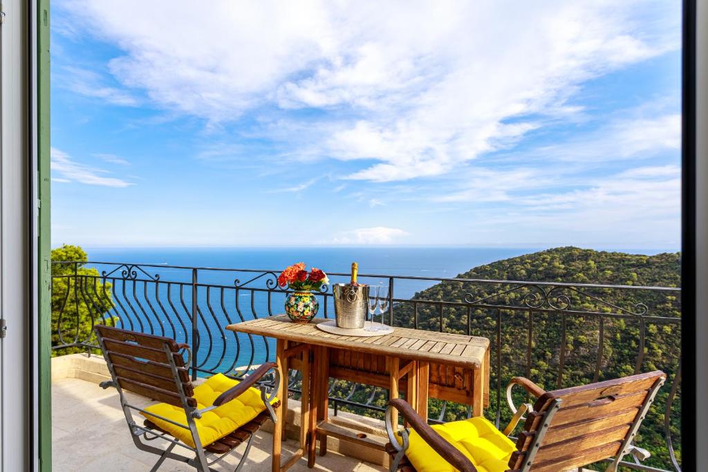 un tavolo e sedie su un balcone con vista sull'oceano di Sea side apartment between Nice and Monaco - 2 a Villefranche-sur-Mer