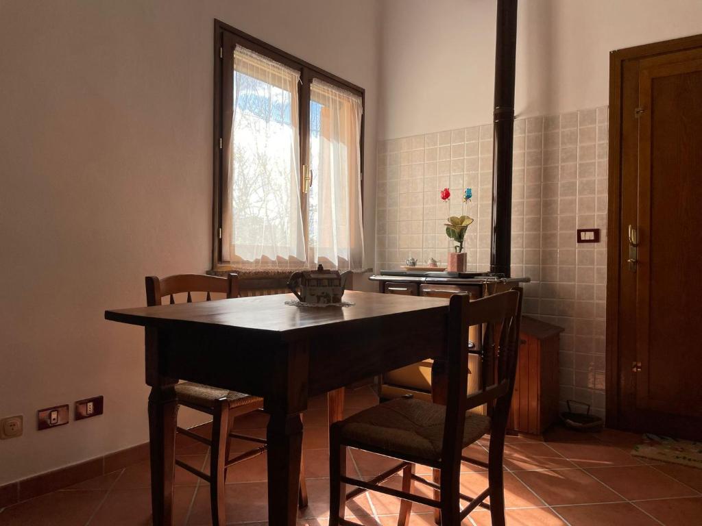 Zimmer mit einem Tisch, Stühlen und einem Fenster in der Unterkunft B&B San Biagio in Marola