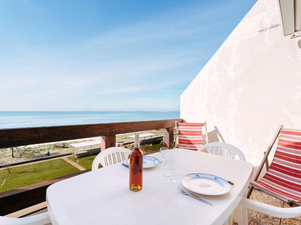 - une table et des chaises blanches avec vue sur l'océan dans l'établissement Studio à Carnac - 22m² - Face à la plage - Balcon - Parking privé - FR-1-477-15, à Carnac