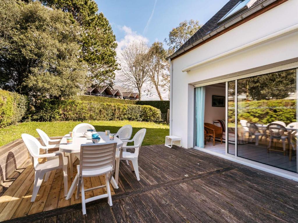 un patio avec une table et des chaises sur une terrasse dans l'établissement Maison 4 pièces avec jardin et piscine chauffée, proche Grande Plage - Carnac - FR-1-477-54, à Carnac