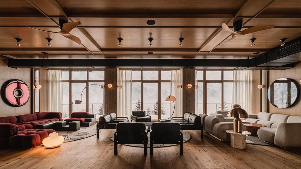 The Comodo Bad Gastein, a Member of Design Hotels في باد جاستاين: غرفة معيشة كبيرة مع كنب وكراسي