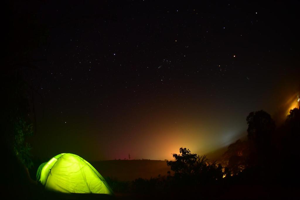 a green tent is lit up in the dark at TENT LIFE in Vagamon