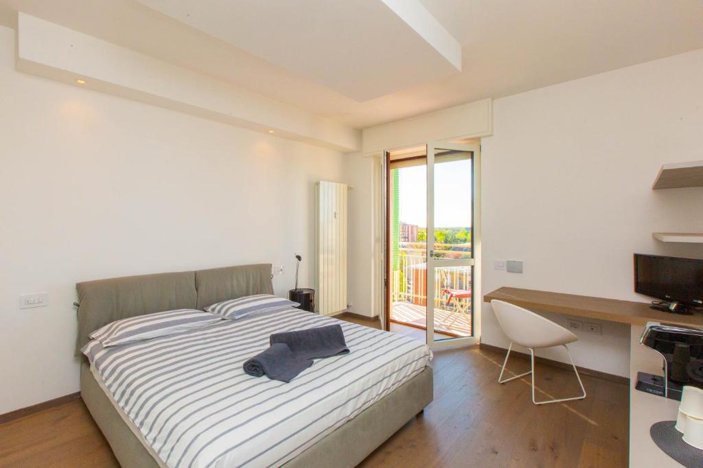 布斯托阿西齊奧的住宿－Al 4，一间卧室配有一张床、一张书桌和一个窗户。