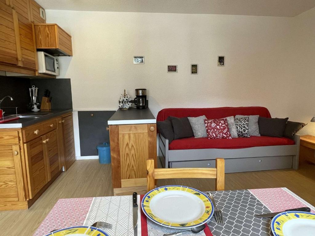 a kitchen and a living room with a red couch at Appartement Saint-Chaffrey , 1 pièce, 4 personnes - FR-1-330E-49 in Serre Chevalier