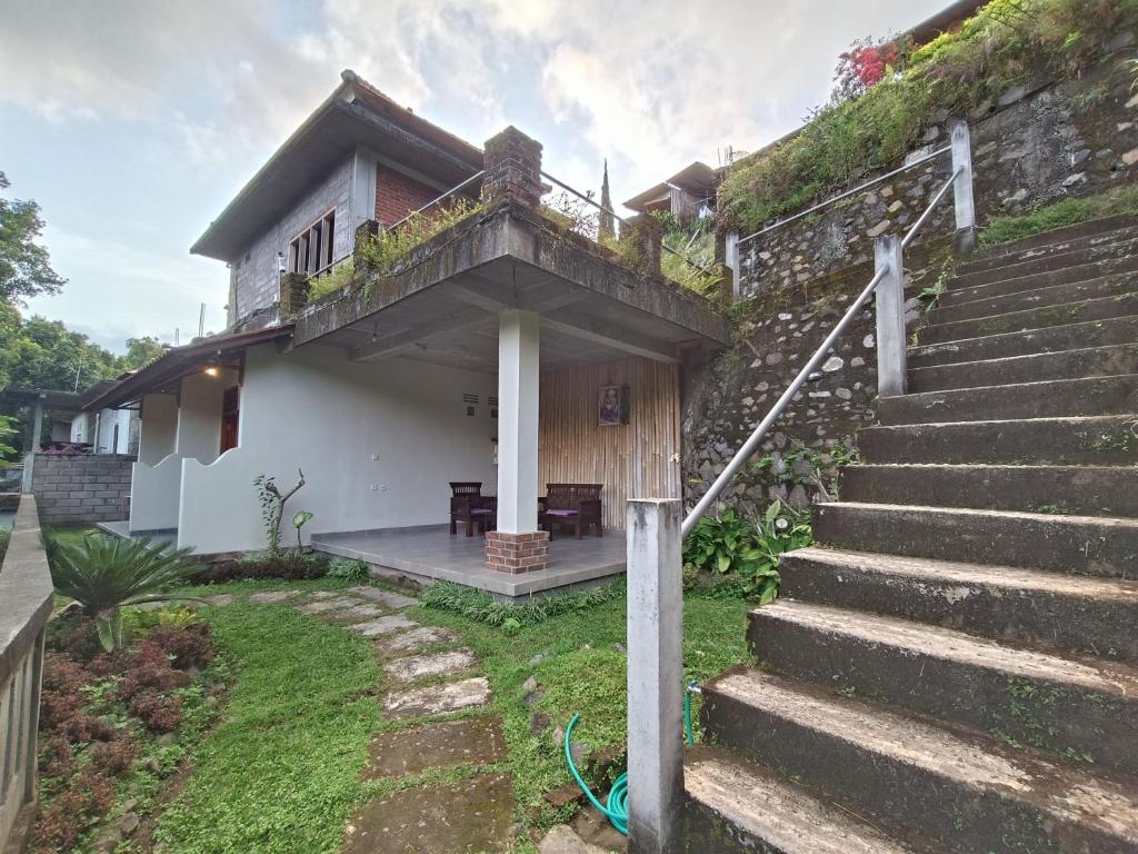 uma casa com escadas que levam até ela em Made Oka Budget Room em Munduk