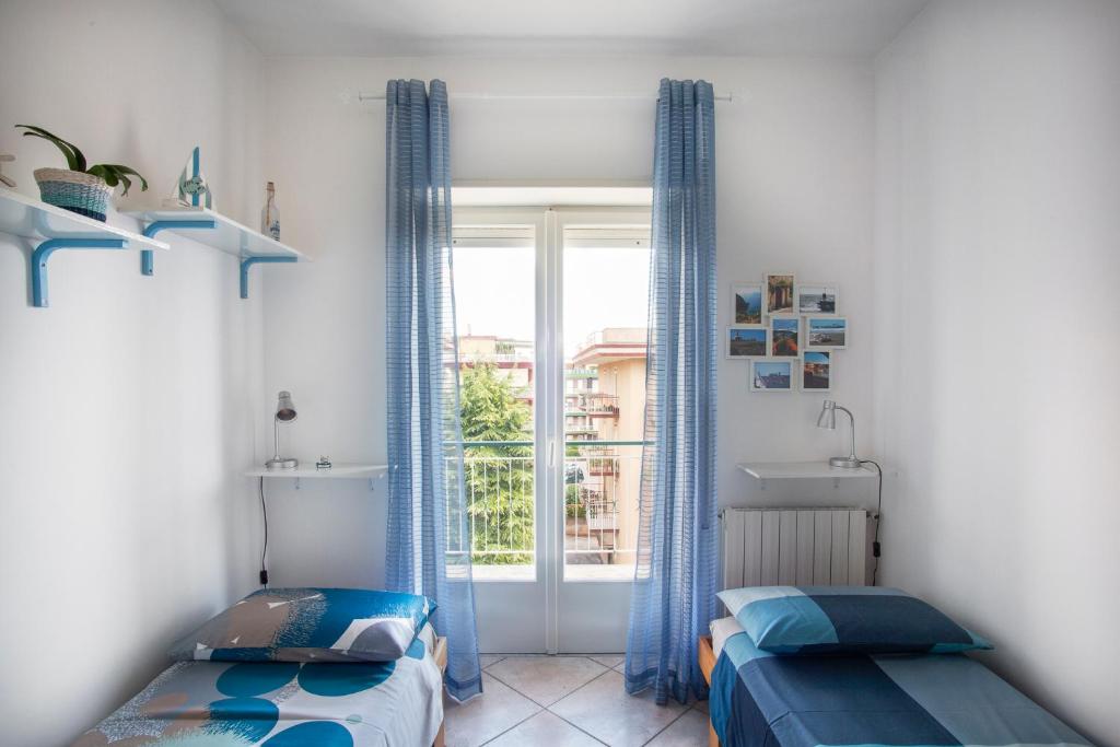 2 Betten in einem Zimmer mit Fenster in der Unterkunft A Casa Scipione in Formia