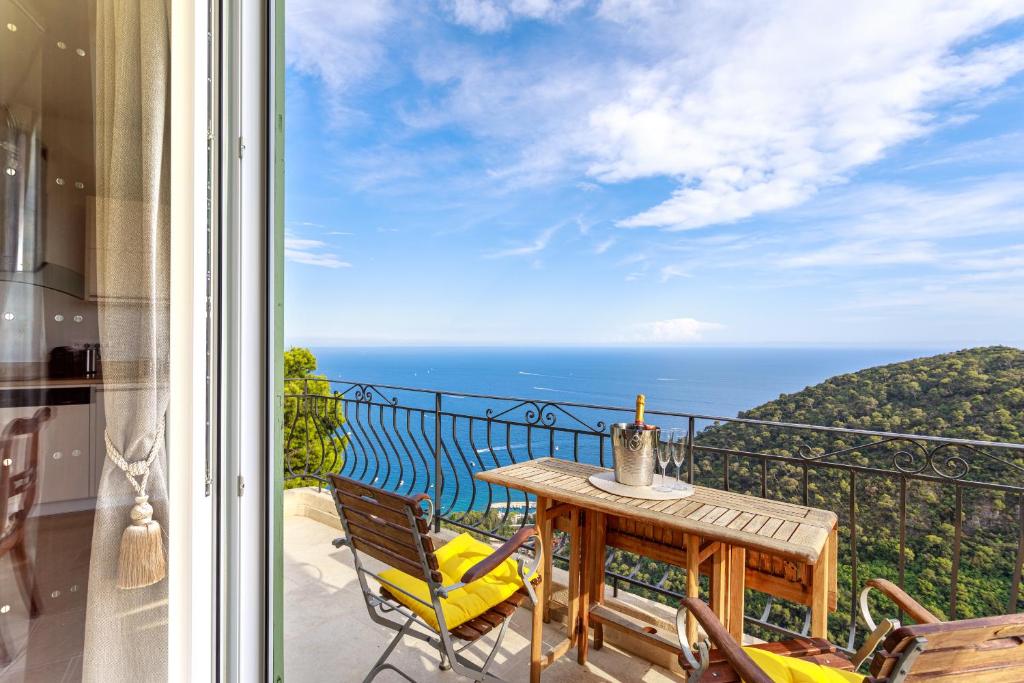 a balcony with a table and chairs and the ocean at Sea terace apartment between Nice and Monaco - 3 in Villefranche-sur-Mer