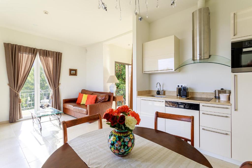 a kitchen with a table with a vase of flowers on it at Sea terace apartment between Nice and Monaco - 3 in Villefranche-sur-Mer