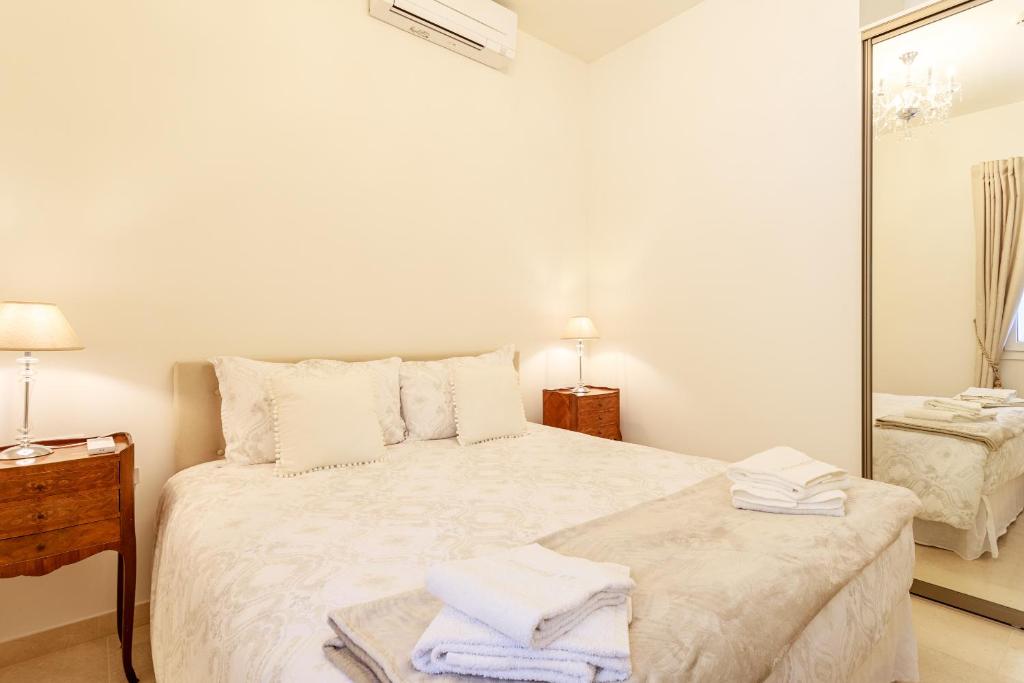 a white bedroom with a large bed and a mirror at Sea terace apartment between Nice and Monaco - 3 in Villefranche-sur-Mer