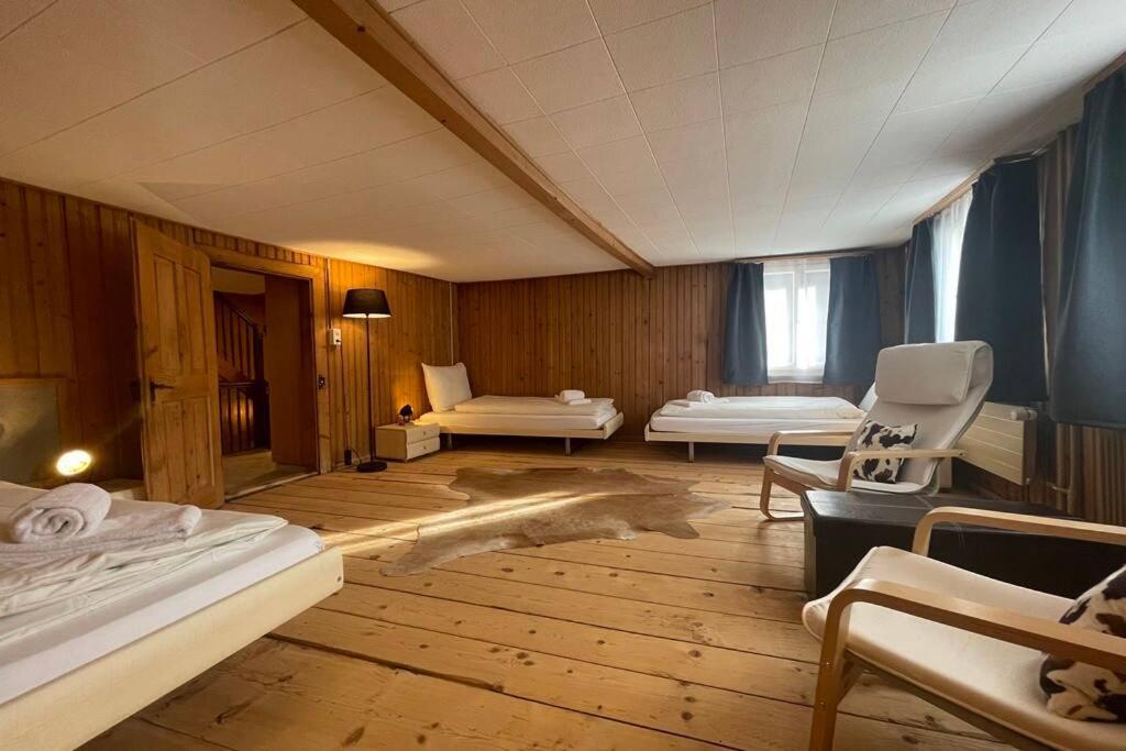 um quarto com duas camas e uma cadeira em 5.5-room apartment (Muntaluna Lodge) em Valens