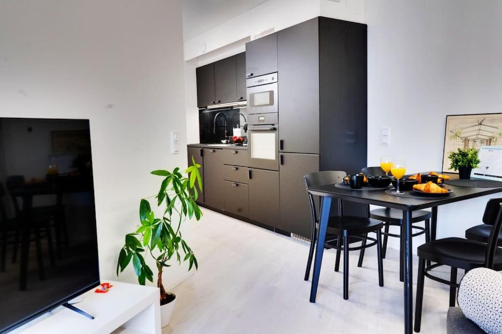 a kitchen with a table and chairs in a room at Best location in Tampere! Modern city apartment, 2rooms, kitchen and balcony in Tampere