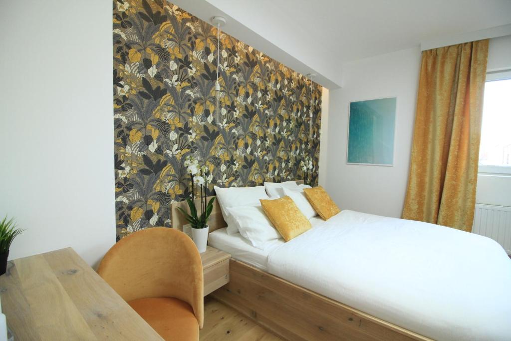 1 dormitorio con cama y pared con papel pintado en Chambres4you, en Namur