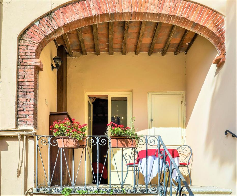 balcón con mesa, sillas y flores en Antica Residenza Santa Chiara-historic centre, en Lucca
