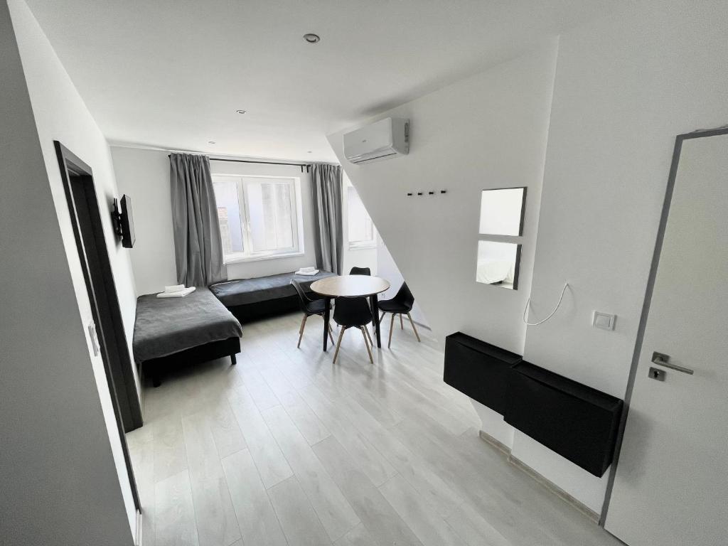 a living room with a table and a bed and a window at MG Apartments Štúrovo in Štúrovo