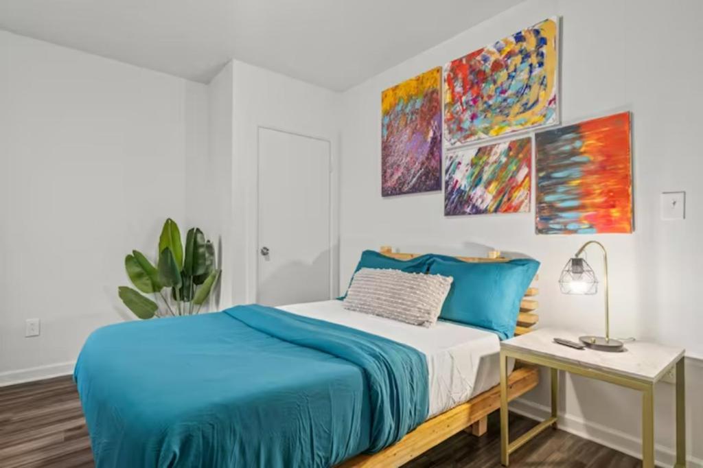 a white bedroom with a blue bed and a desk at Urban Chic Apartments Near Center City in Philadelphia