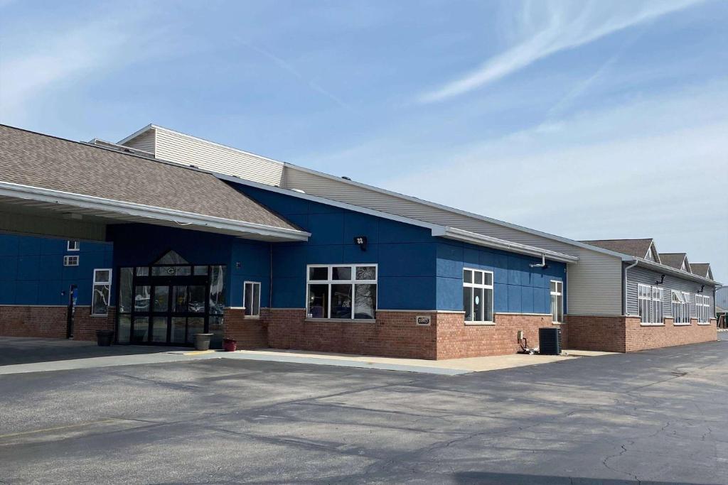 a blue building with a parking lot in front of it at AmericInn by Wyndham Green Bay Near Stadium in Green Bay