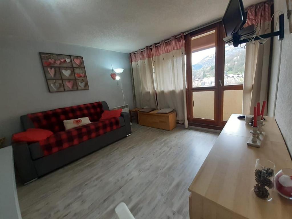 - un salon avec un canapé et une grande fenêtre dans l'établissement Agréable studio cabine à ST LARY SOULAN - 5 couchages, à Saint-Lary-Soulan