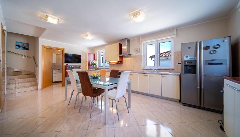 cocina y comedor con mesa y sillas en Grubelic House, en Rab