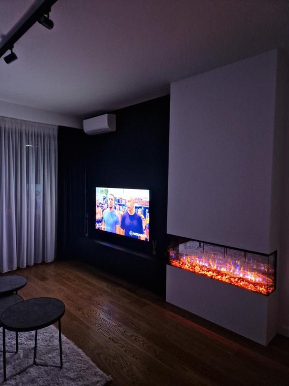 sala de estar con TV y chimenea en TOMAS LUX APARTMENTS, en Banja Luka