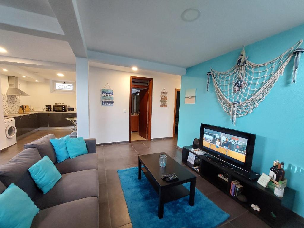 sala de estar con sofá y TV de pantalla plana en O Cantinho do Zé en Funchal