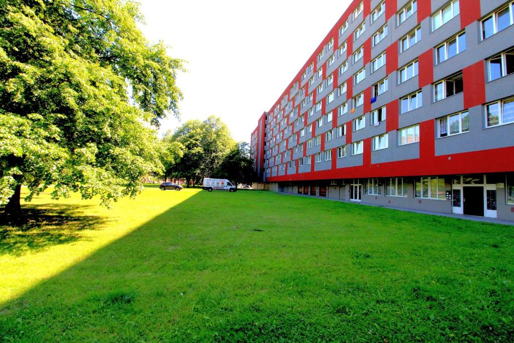 a large grass field next to a red building at Hotelový dům Areál in Ostrava