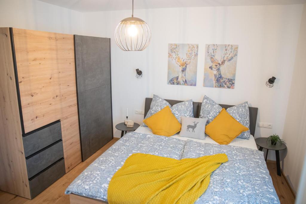 a bedroom with a bed with a yellow blanket on it at Planaiblick-Lodge Schladming in Schladming