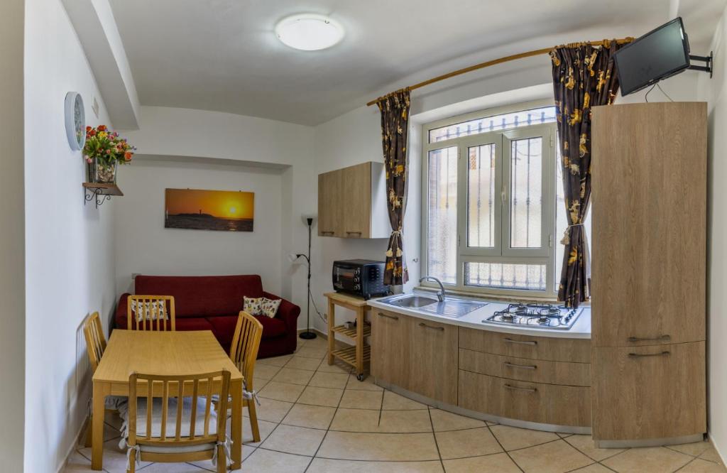 cocina y sala de estar con mesa y sofá en casa al mare Ippolito, en Santa Maria di Castellabate