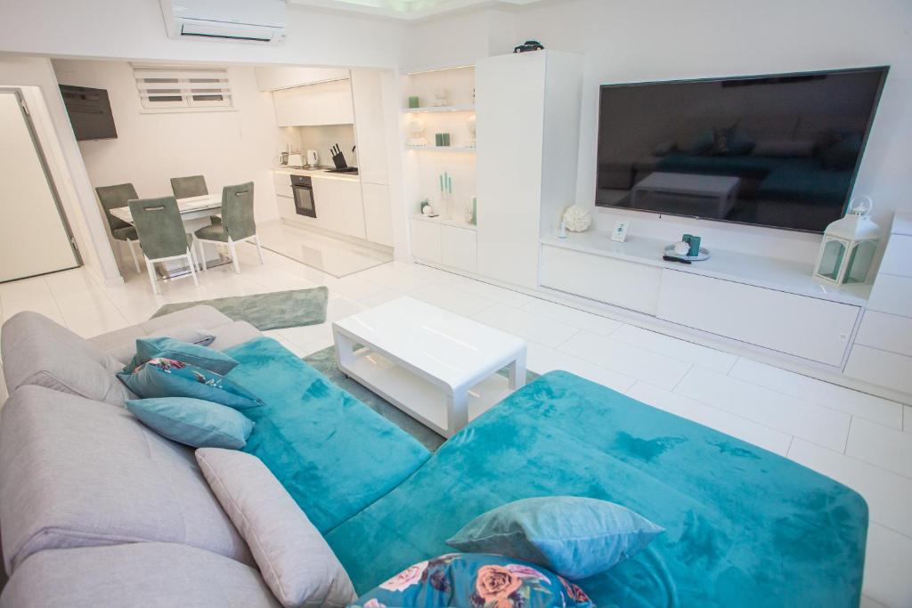 uma sala de estar com um sofá e uma televisão em Apartman Pascal em Porec