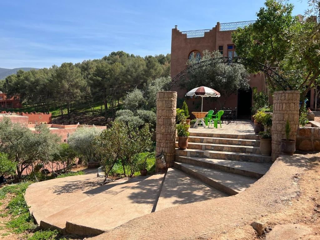 una casa con scale e un tavolo e un ombrello di Maison d´hôtes Amazir a Ouzoud