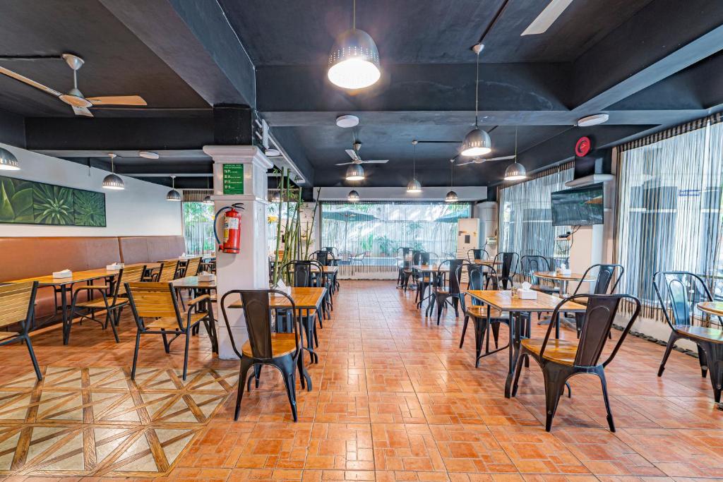 - un restaurant avec des tables et des chaises dans une salle dans l'établissement Hotel Athome , Whitefields, Kondapur, à Hyderabad