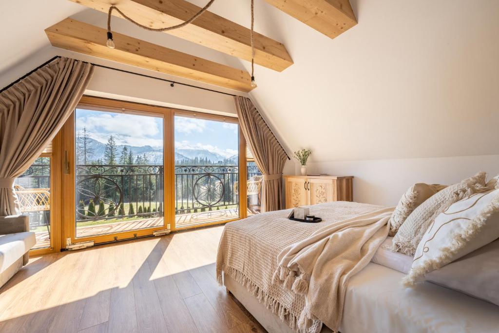 sypialnia z łóżkiem i dużym oknem w obiekcie Góralska Strefa Domki & SPA w mieście Kościelisko