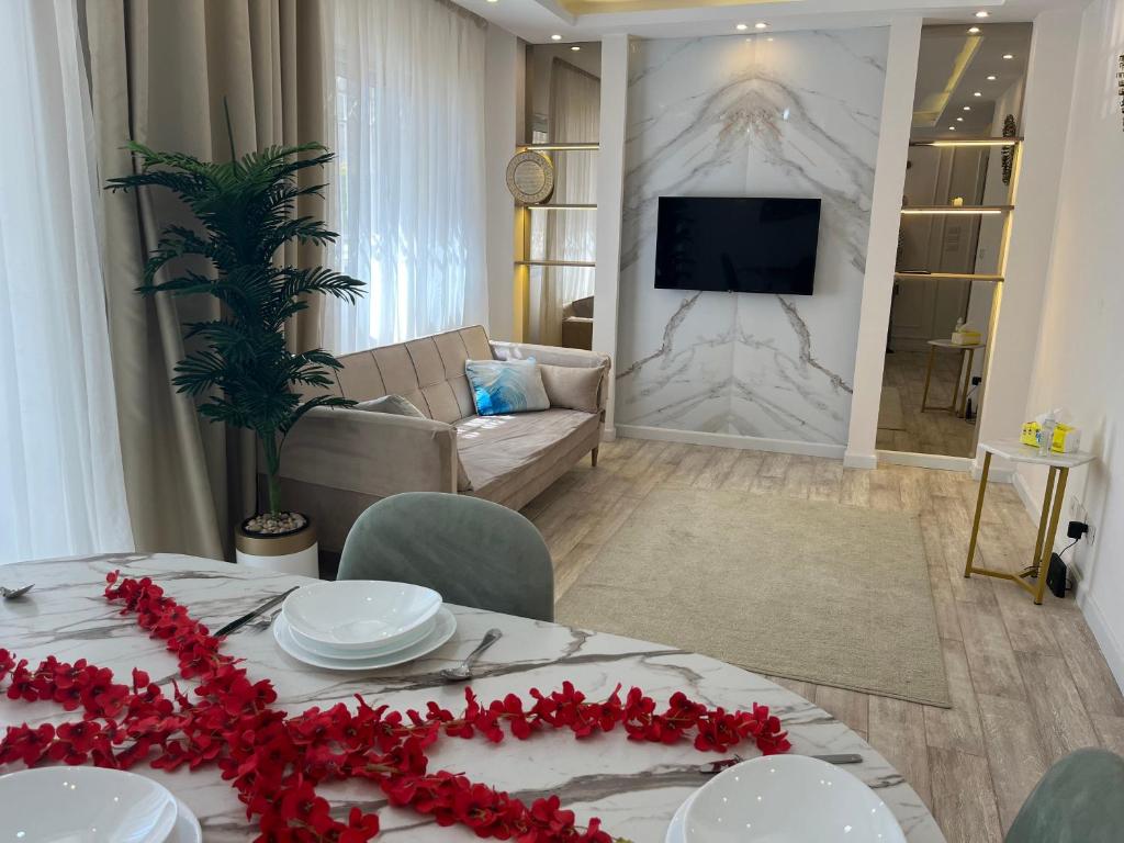 a living room with a table with red flowers on it at Madinaty, Elite new studio families and married couples only in Madinaty