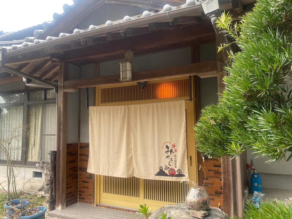 eine Eingangstür eines Hauses mit einem Vorhang darauf in der Unterkunft みやうら御殿 in Imabari