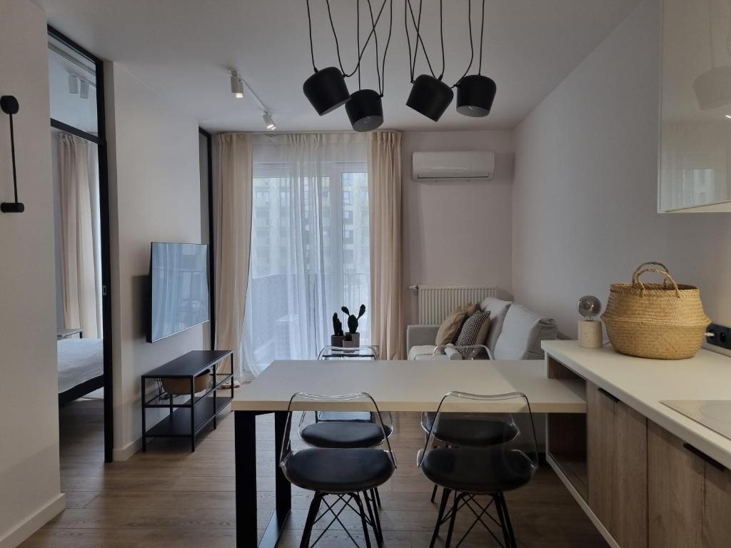 羅茲的住宿－Fuzja Ana - Garaż - Klimatyzacja - Dostęp na Kod - FV，厨房以及带桌椅的起居室。