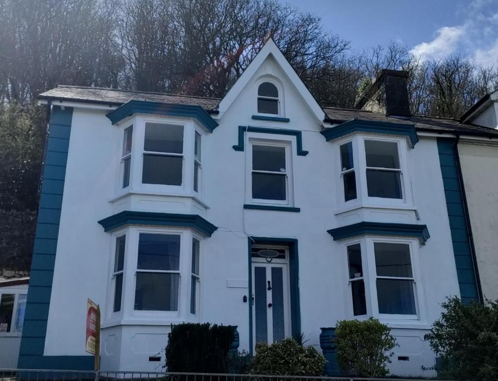 a white house with blue trim at Woodlands Bellevue Bed & Breakfast in New Quay