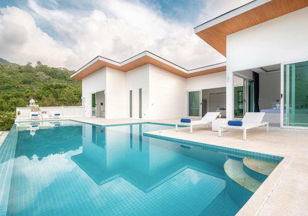 a villa with a swimming pool and a house at Vimaan Vilai - Secluded Pool Villa in Amphoe Koksamui