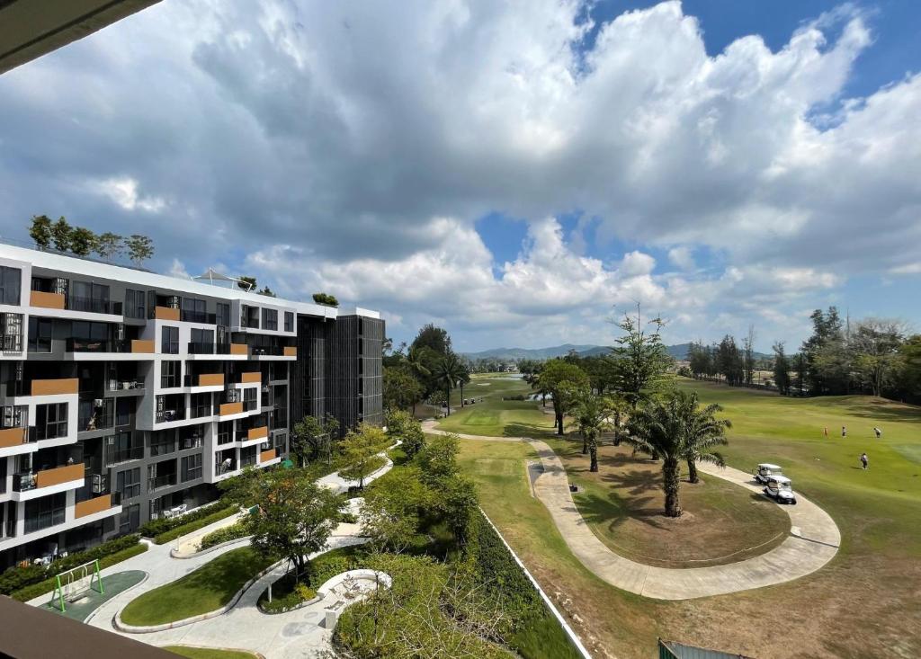 een luchtzicht op een gebouw en een golfbaan bij Brand new Condo in Laguna near golf course in Bang Tao Beach